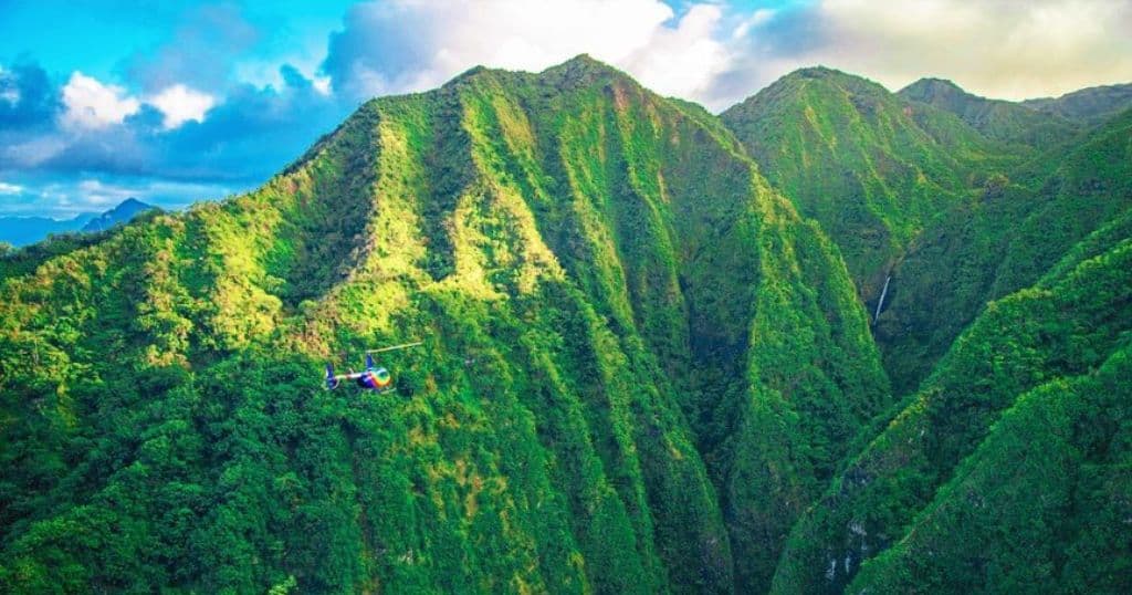 helicopter flying over the mountains in oahu, hawaii.