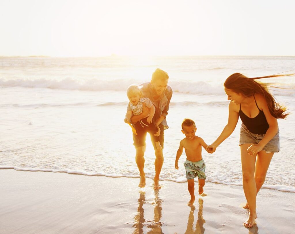 family on the beach during sunset.