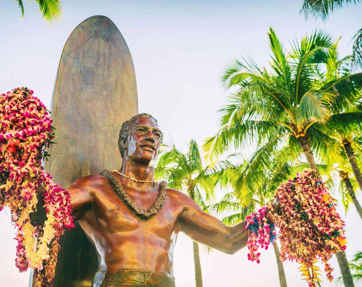 statue with flower leis in the beginning of waikiki beach.