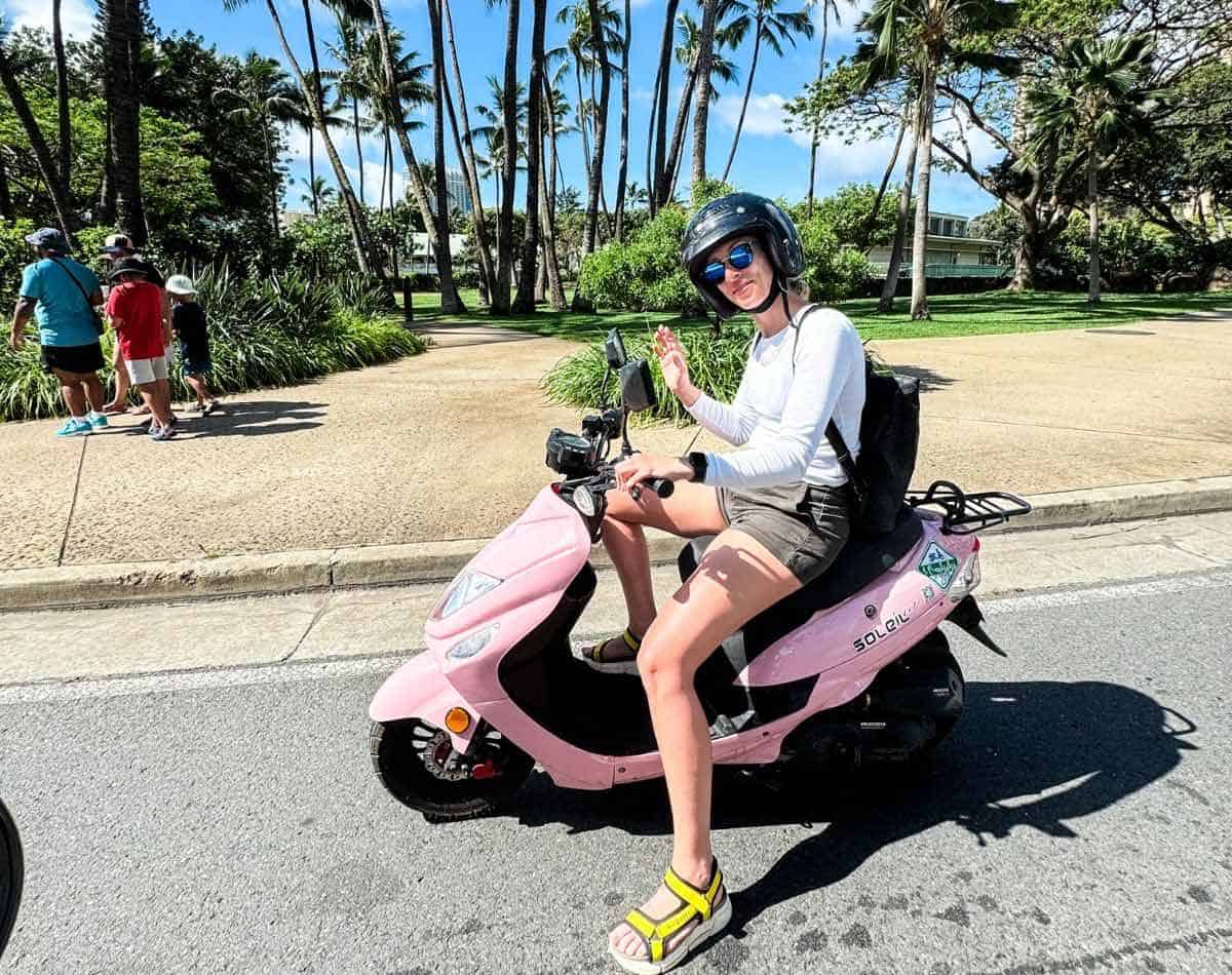 girl on a moped scooter in waikiki oahu.