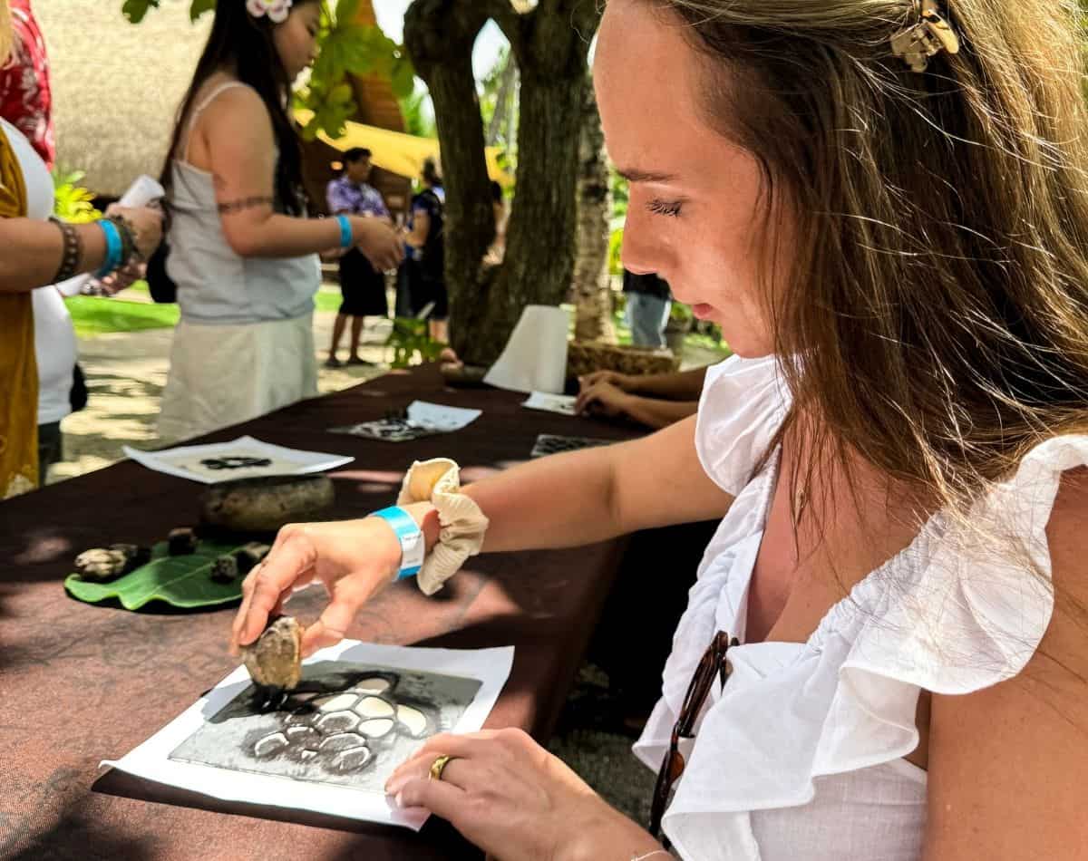 a girl making a turtle picture in polynesian cultural center.