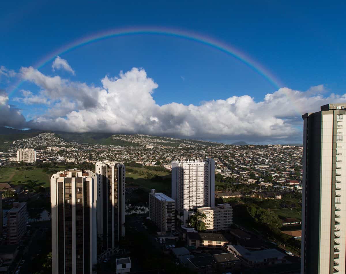 Rainbow over Honolulu city backdrop.