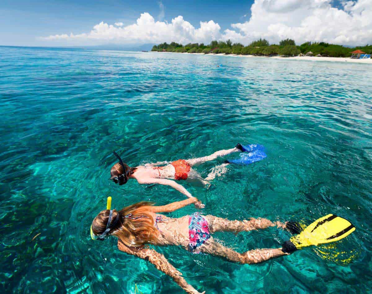 snorkeling people in ocean in hawaii.