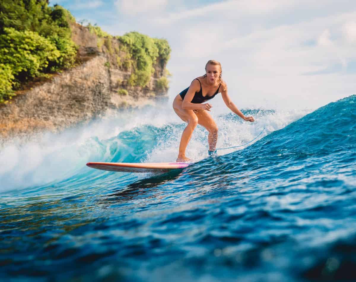 a girl surfing in hawaii.